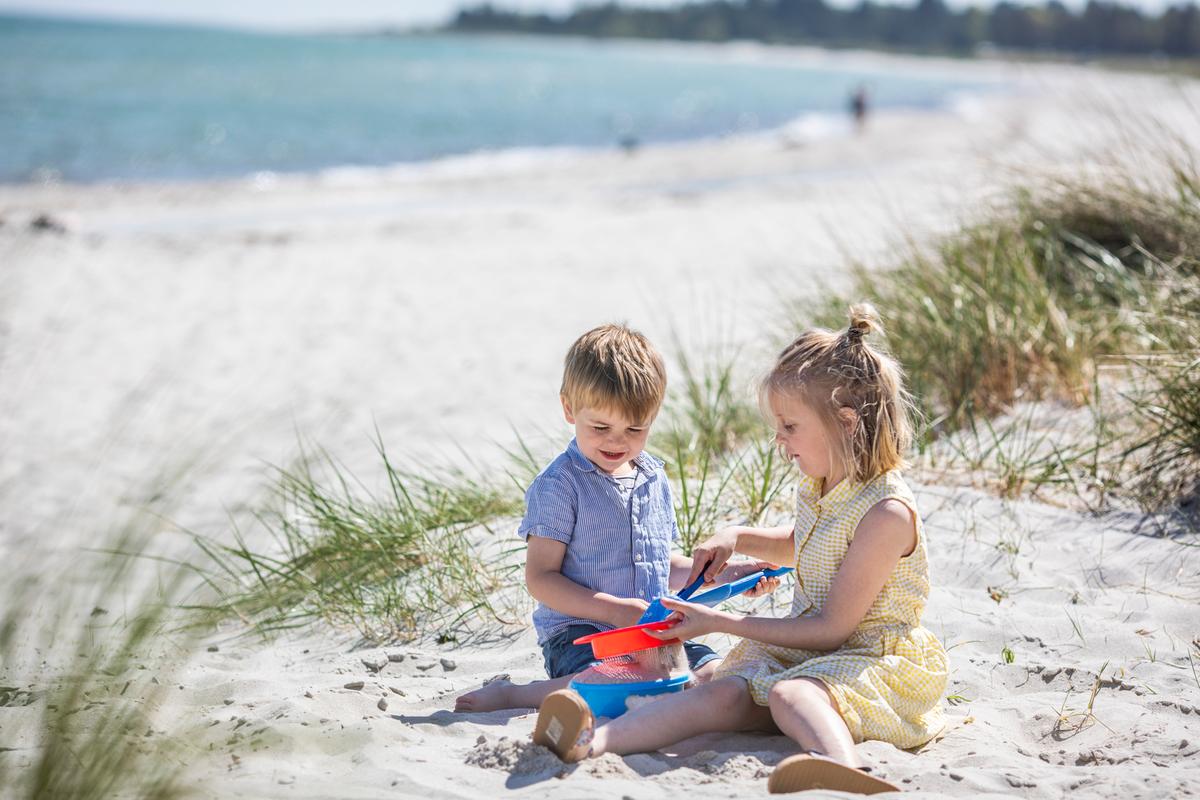 Kinder spielen auf dem Strand von Saksild