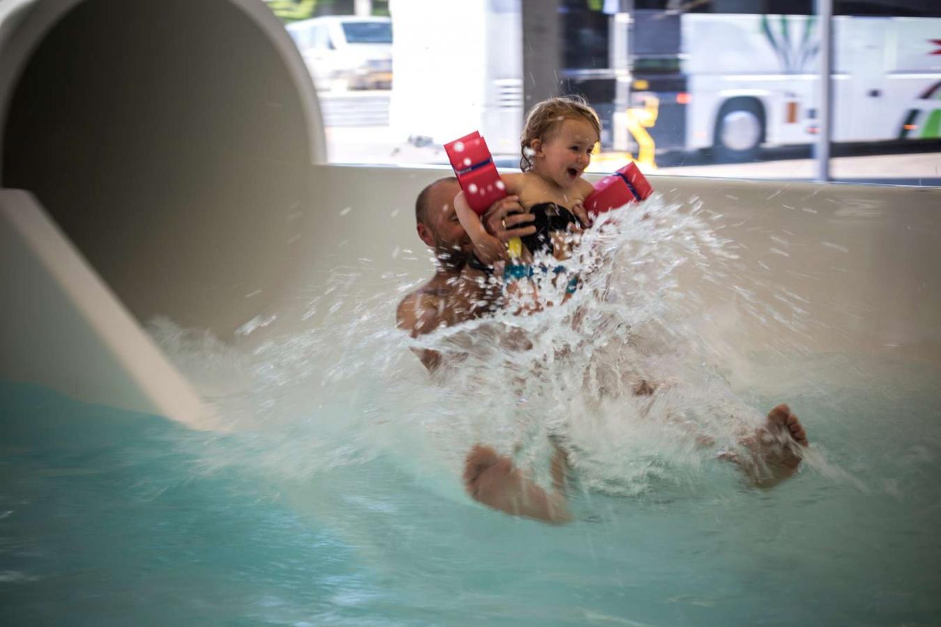 Vater und Tochter kommen in Vandhalla in Hou von der Wasserrutschbahn geflogen