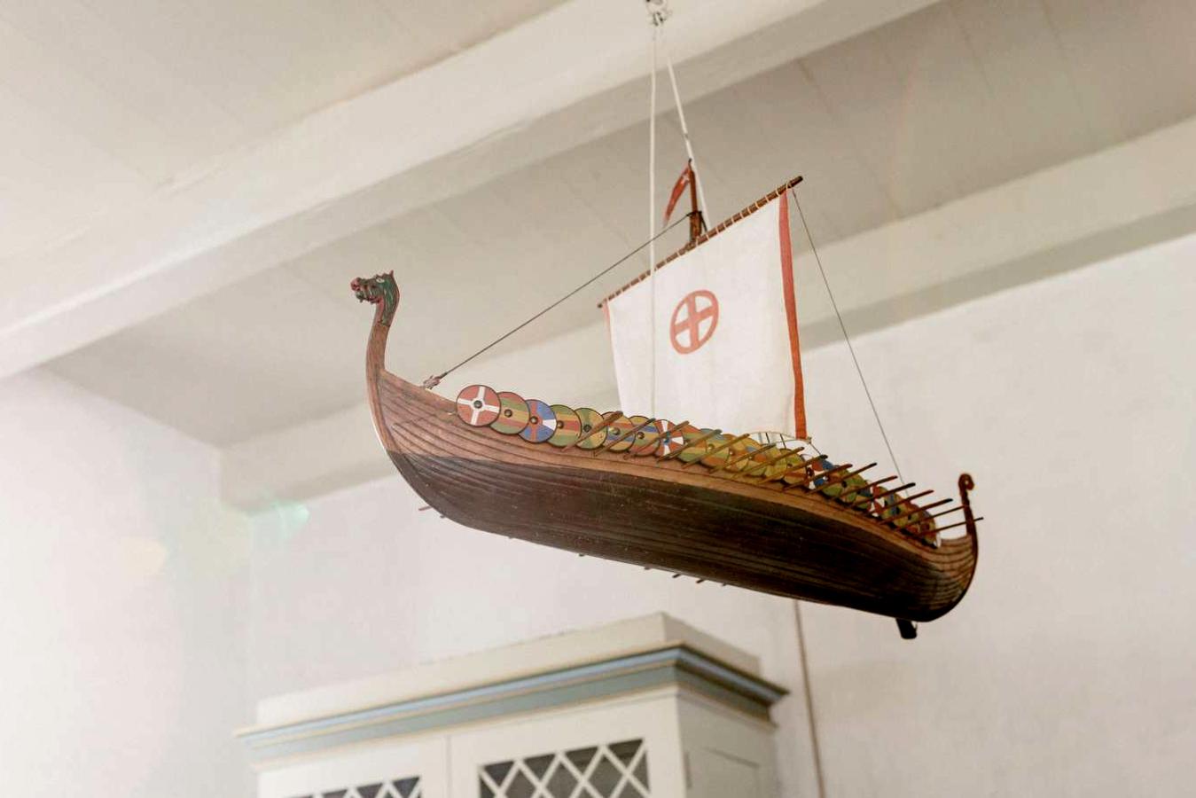 Das von der Decke hängende Wikingerschiff kann man in Dänemarks zweitkleinster Kirche auf Hjarnø im ostjütischen Inselmeer sehen