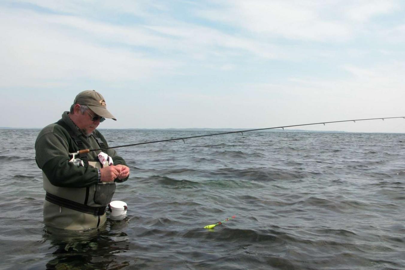 Mand sætter madding på krogen på fisketur