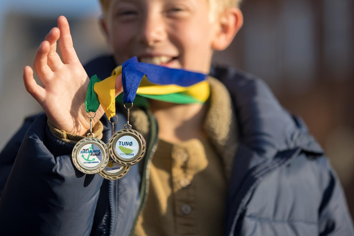 Skattejagten Rundt Destination Kystlandet dreng holder medaljer