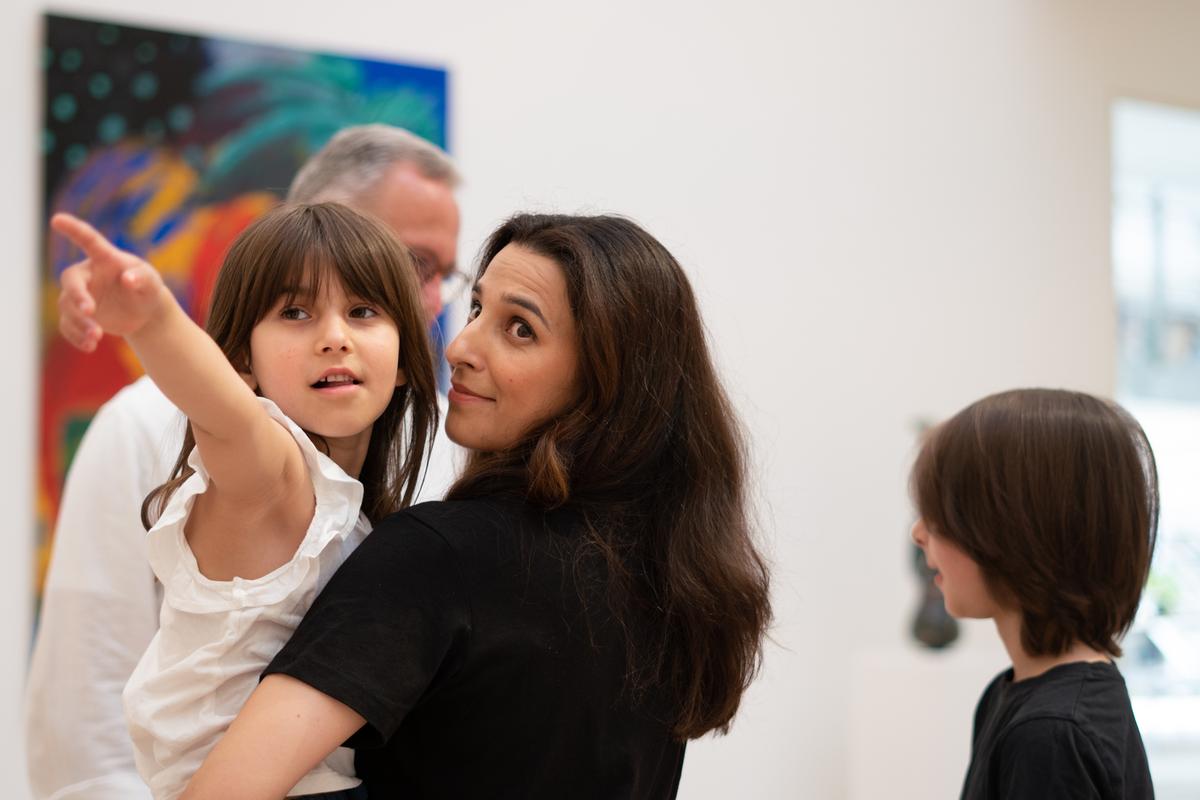 pige peger mod et billede på Horsens Kunstmuseum i Kystlandet, mens hun hænger på hendes mor.