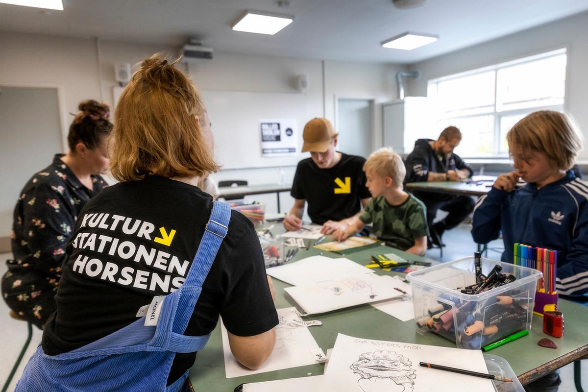 Kinder und Familien sitzen in der Kulturstation in Horsens in der Urlaubsregion Küstenland an einem Tisch und zeichnen