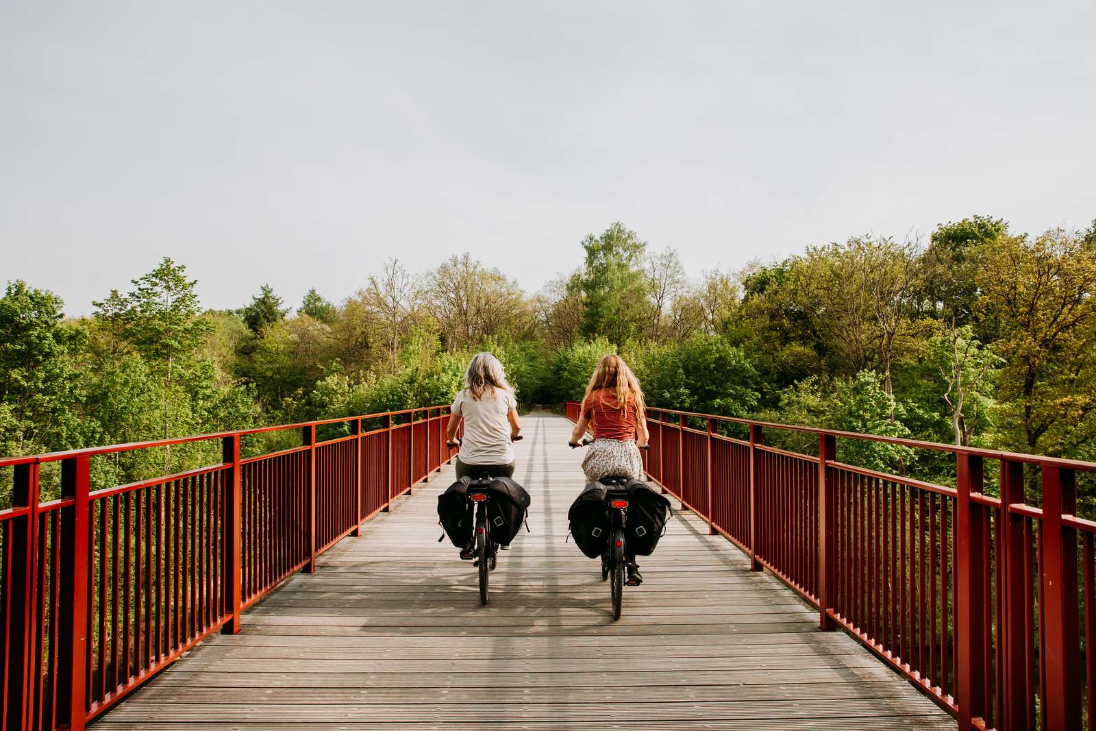Kvinder cykler på elcykler på Den Genfundne Bro
