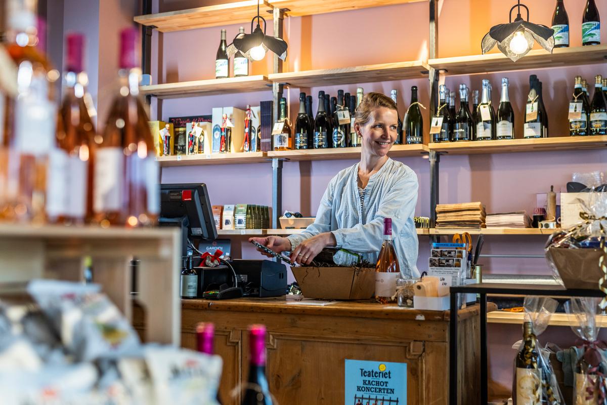 Kvinde står bag skranke i butik